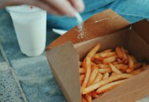 나트륨 섭취를 줄이는 저염식 다이어트 person sprinkling salt in fries