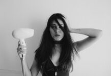 “두피부터 모발까지, 건강하게 지키는 생활 속 헤어 케어 트렌드” woman in black tank top holding her hair