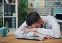 만성피로, 일상 속 작은 변화로 극복…한국인의 슬기로운 피로 관리법 a man sitting at a desk with his head in his hands