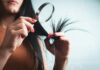 건강한 머릿결, 생활 습관이 먼저다… 실천 가능한 헤어 케어 트렌드 Woman examining split ends of hair with magnifying glass
