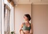 “필라테스로 달라진 일상… 집에서도 가능한 실천 루틴 인기” a woman in a green sports bra top and leggings holding a yoga mat