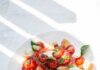 집에서도 손쉽게, ‘마음챙김 먹기’ 건강 트렌드… 바쁜 일상 속 실천법은? sliced tomato and green leaf vegetable on white ceramic plate