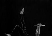 집에서 만나는 필라테스, 건강한 일상의 새로운 기본으로 자리잡다 woman in black pants and black boots lying on black wooden bench