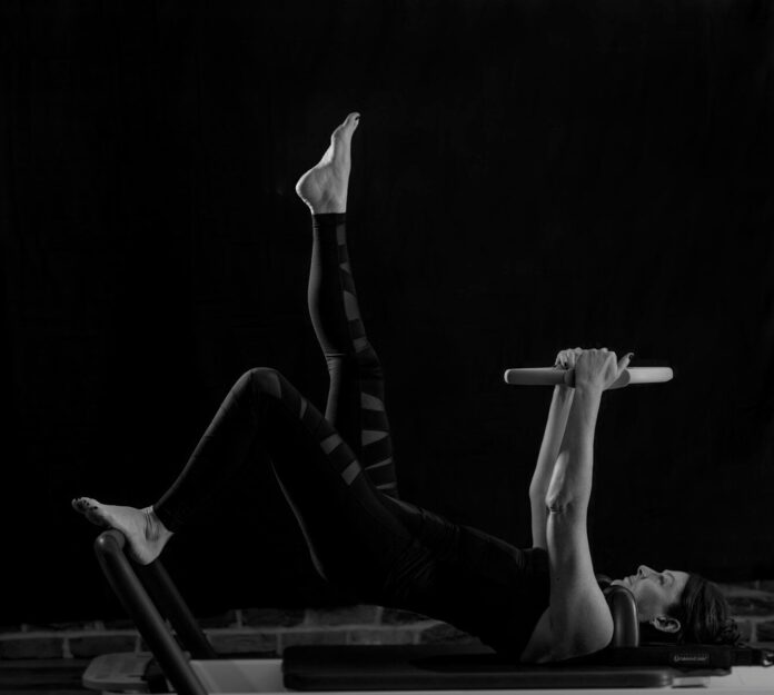 Photo by Helen Thomas woman in black pants and black boots lying on black wooden bench